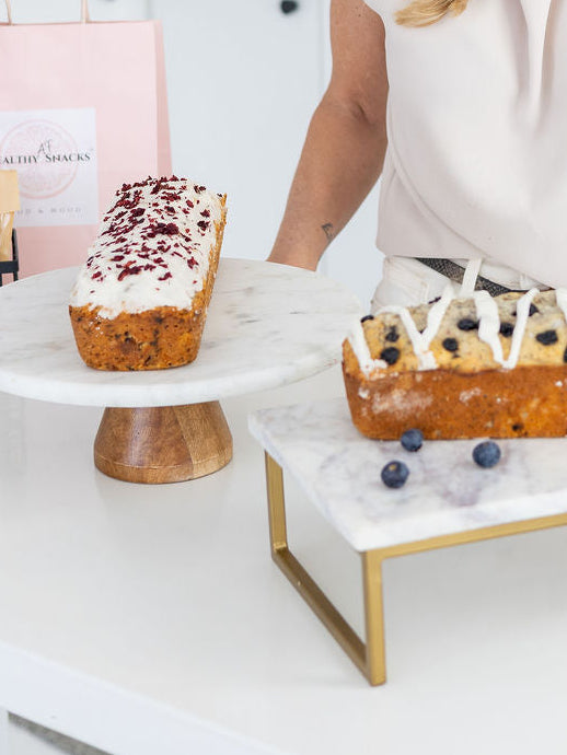 Woman standing behind a counter with pastries in a bakery setting