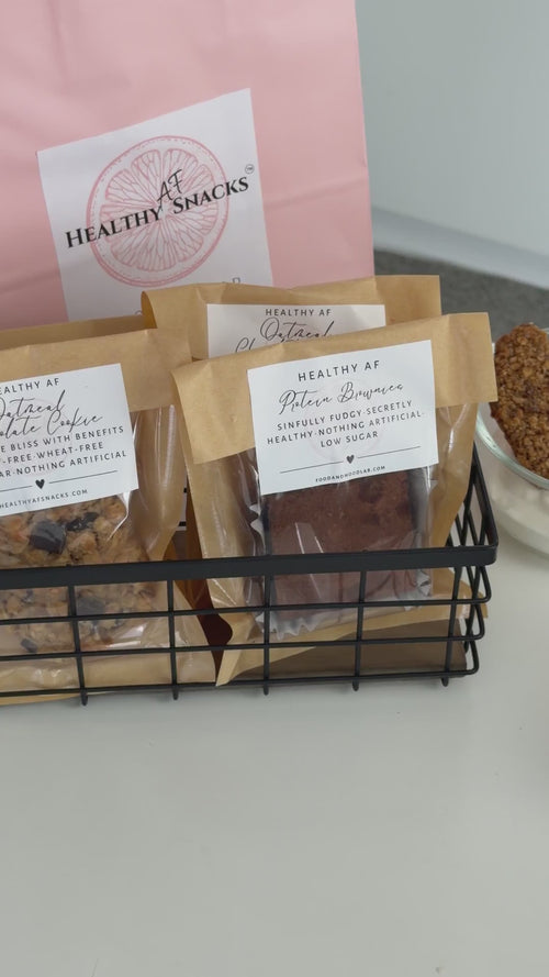 packaged cookies, mug with coffee, and granola in a bag on a table